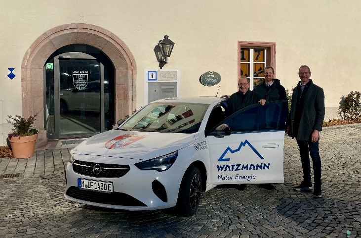 Drei Männer stehen neben dem E-Bürgerauto der Stadt Laufen.