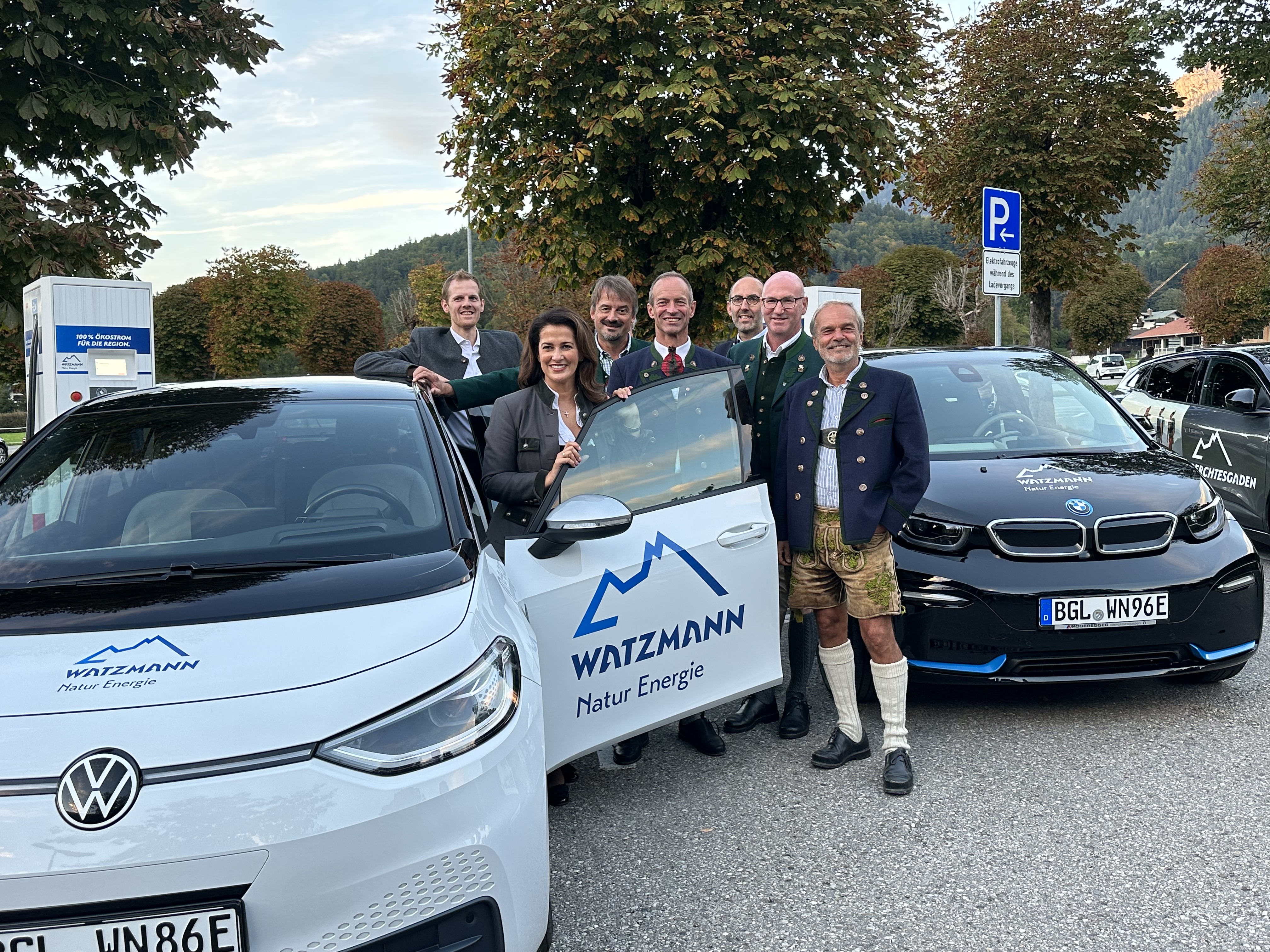 Sieben Personen neben einem E-Carsharing Fahrzeug der Watzmann Natur Energie zur Eröffnung des Ladeparks und Start des E-Carsharings am Königssee.